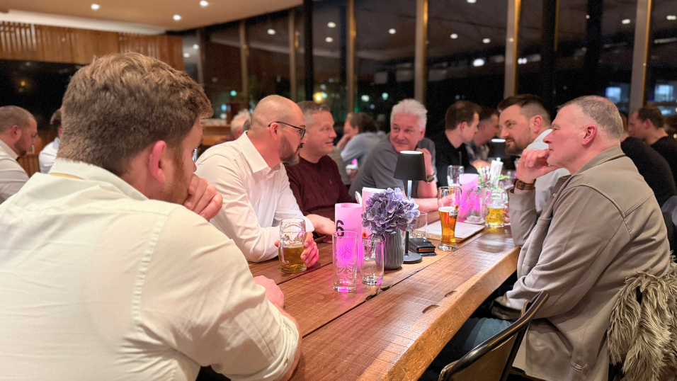 Teilnehmer sitzen im Restaurant der Abendveranstaltung und unterhalten sich 