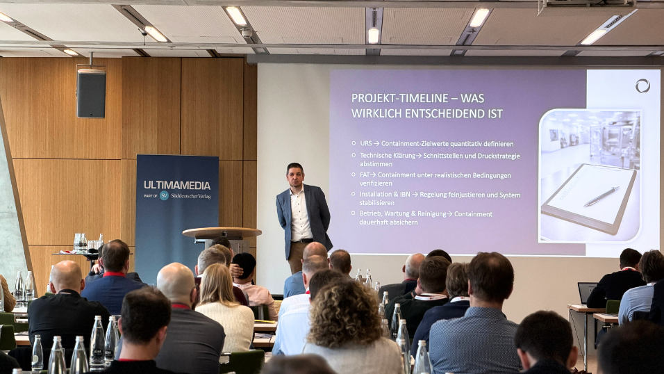 Christopher Muschiol von HET Filter GmbH steht auf der Bühne und hält seinen Vortrag zu "Containment mit System" und redet zum Publikum