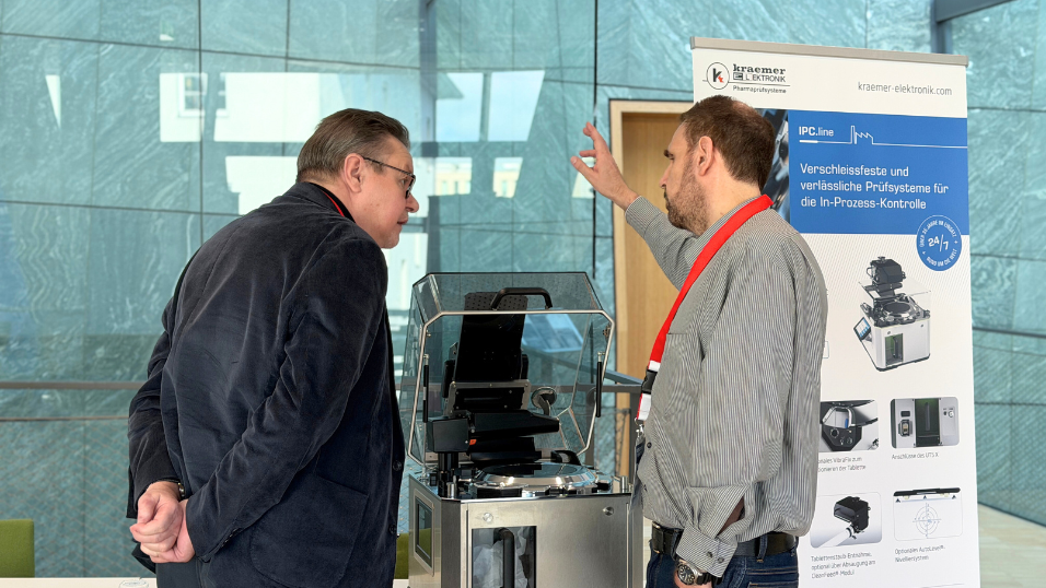 Teilnehmer unterhalten sich vor dem Kraemer Elektronik Stand